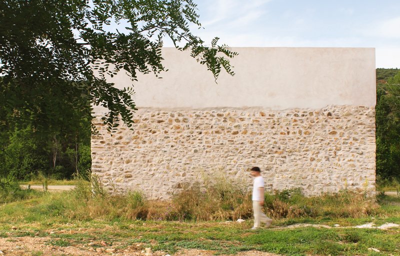Plain rear elevation of the building with stone base and white plaster top