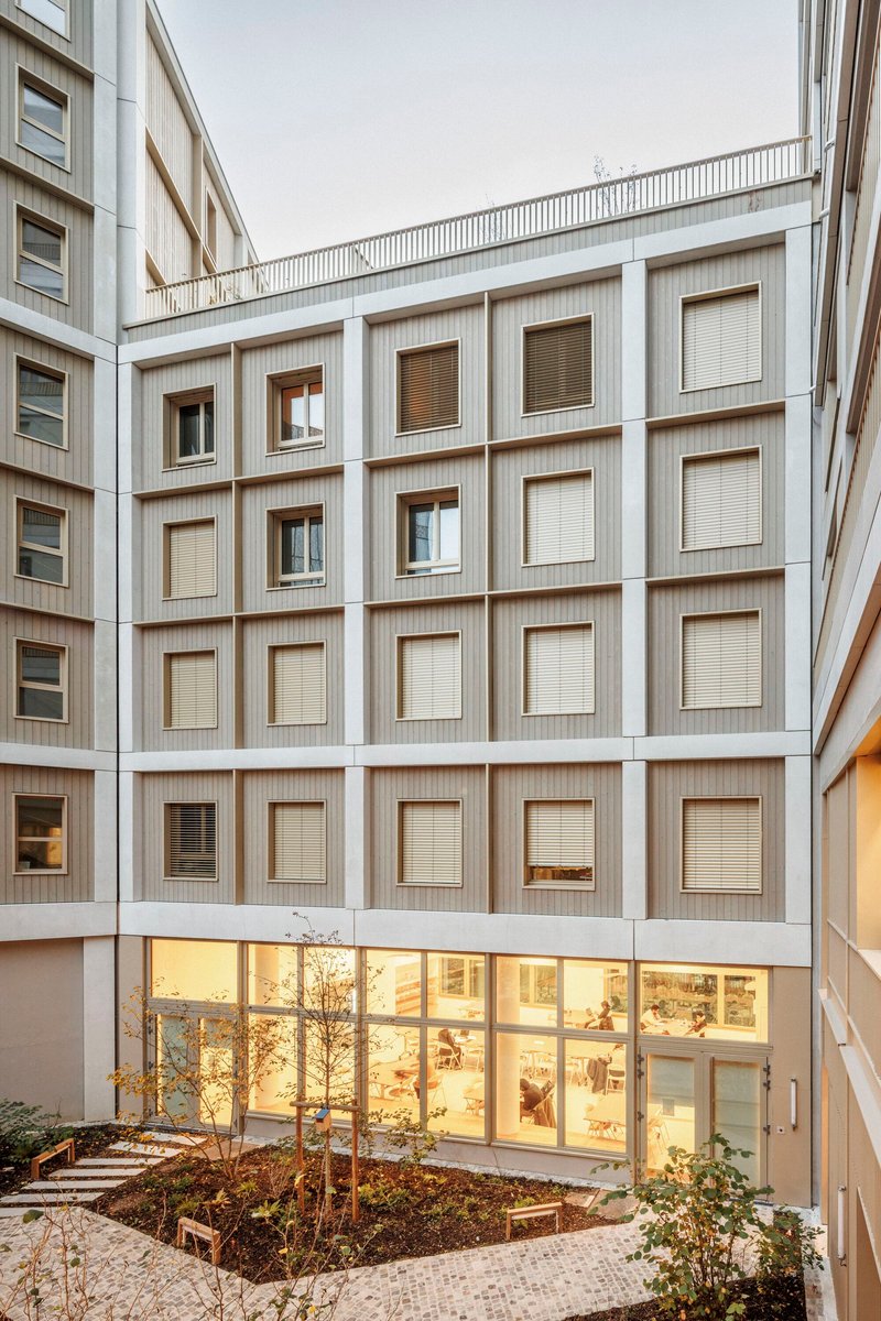 Internal courtyard of the student residence with the lit media library on the ground floor
