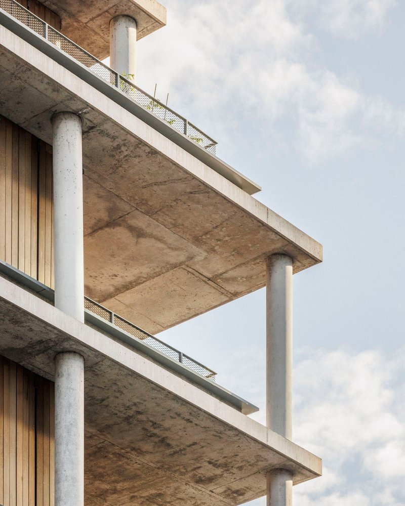 Close-up of the cantilevered concrete slabs and round columns at the building corner