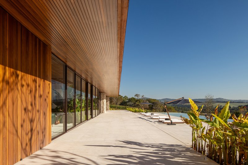 Wide covered terrace with stone paving and a timber slatted ceiling looking toward the surrounding countryside
