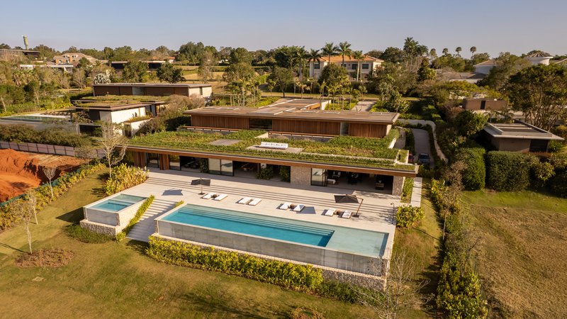 Aerial view showing the green roof planted over the long horizontal volume and the pool terrace below