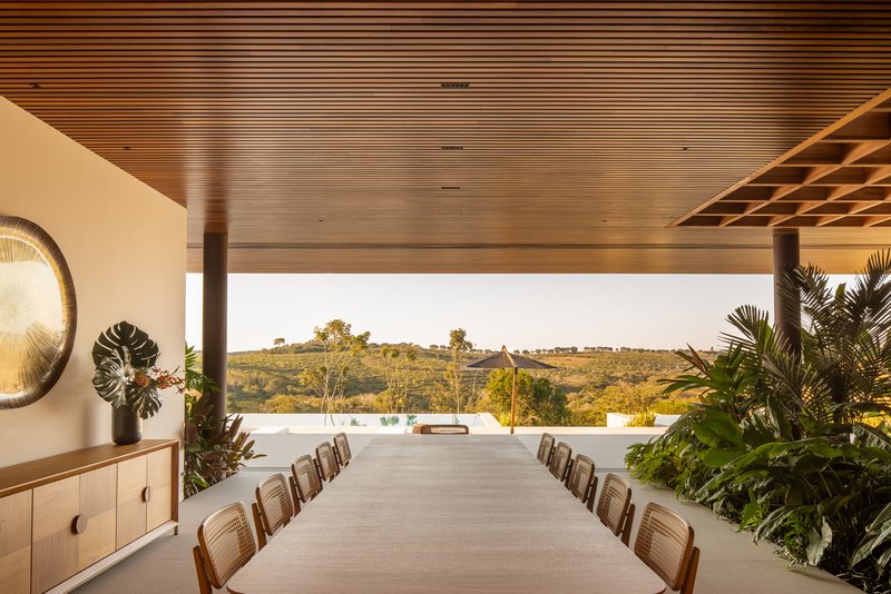 Dining room looking out to the pool terrace and the hills with a circular hammered metal artwork on the side wall