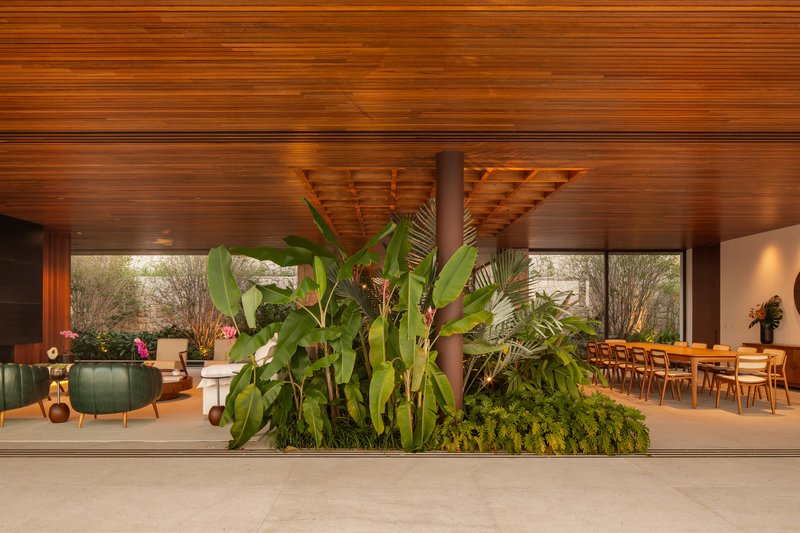 Central vestibule with a large planted bed separating the living and dining zones under the timber ceiling
